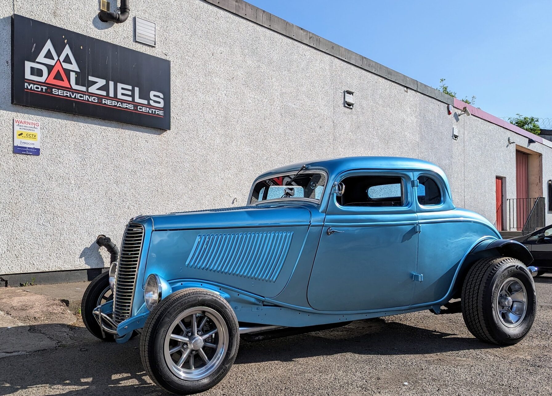Classic blue Car outside Dalziels Garage 2024