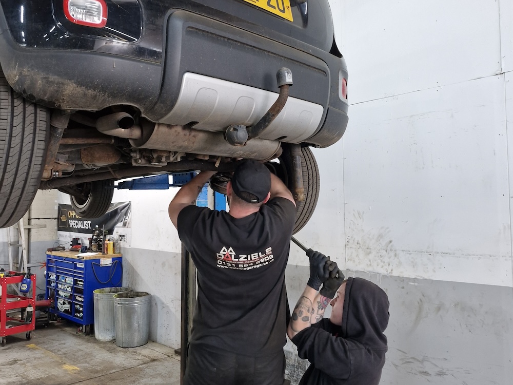 Mechanics working on car in Dalziels Garage 2024